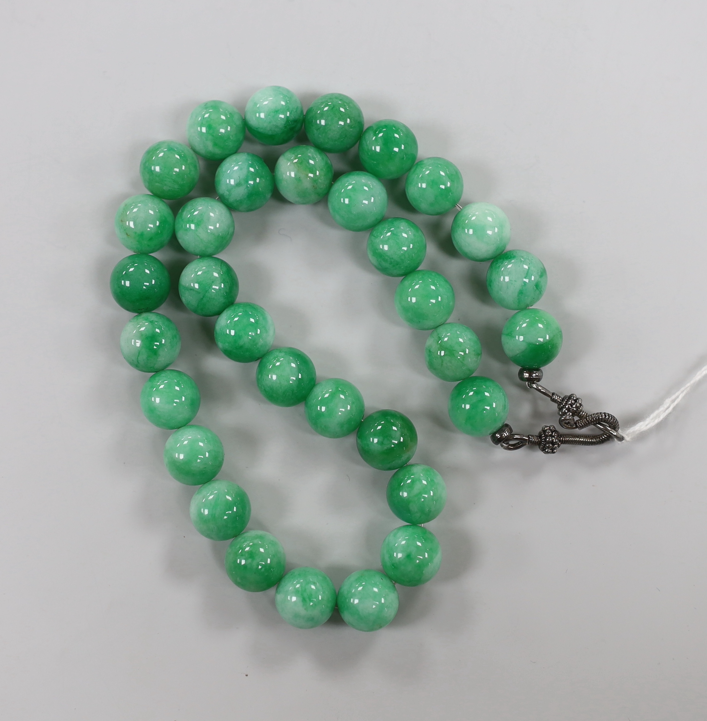A single strand jade bead necklace, with white metal clasp, beads approximately 14mm in diameter, 44cm.